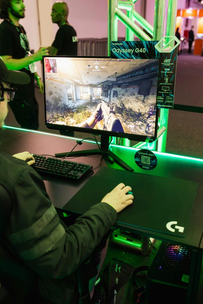 A focused gamer using Samsung Odyssey G40 for immersive video gaming at an event.