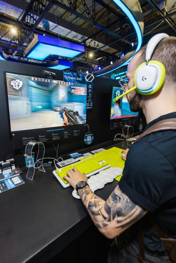 Man playing a video game with advanced peripherals at a technology trade fair.