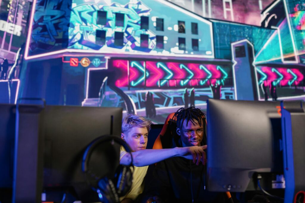 Two gamers having fun and playing a video game together in an immersive esports environment indoors.
