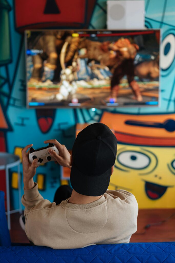 Man wearing cap playing video game with controller, relaxed and focused.